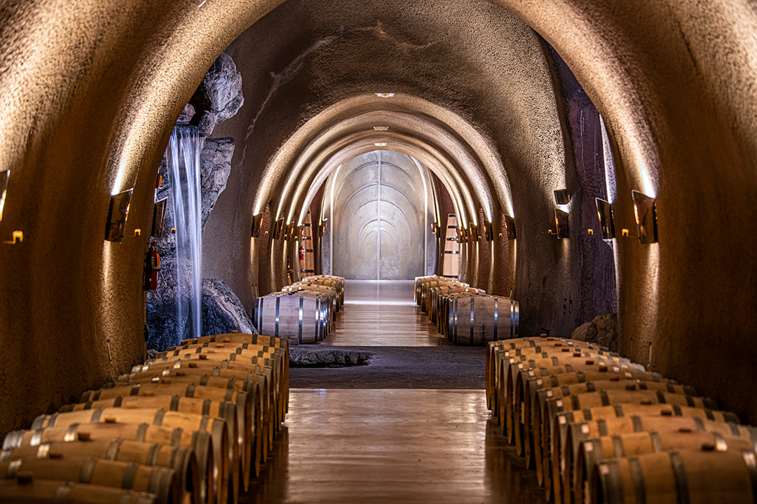 Underground wine barrel aging in the cave at Jarvis Estate with a view of waterfall